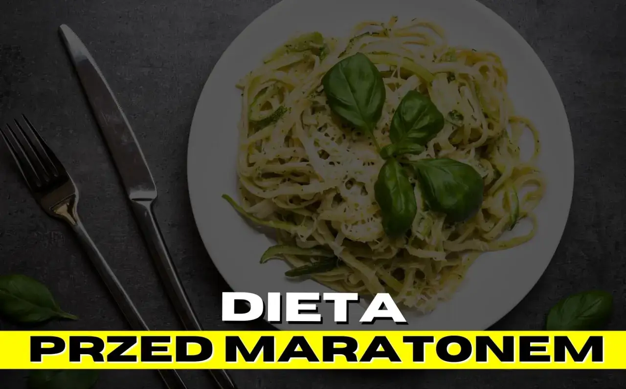 Talerz makaronu z bazylią i cukinią, idealny na dietę przed maratonem. Sztućce obok.